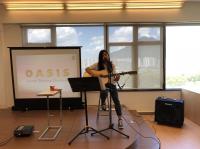A student gives a solo guitar and singing performance.